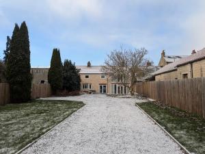 a driveway leading to a house with a fence at Rye Court Cottages in Helmsley