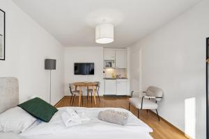 una camera da letto bianca con un letto e un tavolo di City-Studio - sweet and modest - Crown 14 a Zurigo