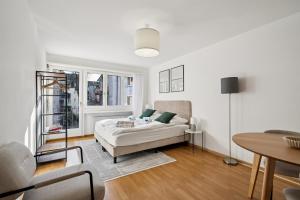una stanza bianca con un letto e un tavolo di City-Studio - sweet and modest - Crown 14 a Zurigo