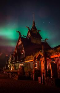 Casa anooky com as luzes verdes do norte no céu em Hotel Viking em Hafnarfjördur