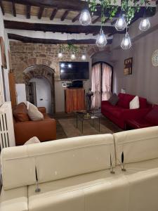a living room with two red couches and a brick wall at Vicolo San rufino in Assisi