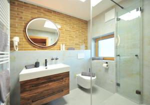 un bagno con lavandino, WC e specchio di Appartements & Chalets Wiesenruh a Bichlbach