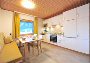 una cucina con un tavolo e una sala da pranzo di Appartements & Chalets Wiesenruh a Bichlbach