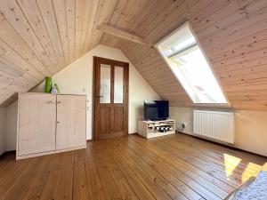 an attic room with a wooden ceiling and a window at Chalupa Za Vraty Jevišovice in Jevišovice