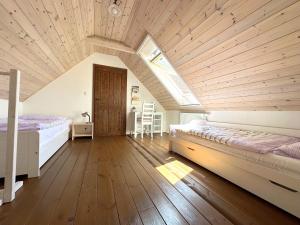 a attic bedroom with two beds and a skylight at Chalupa Za Vraty Jevišovice in Jevišovice