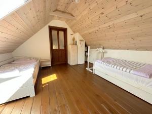 two beds in a attic bedroom with wooden floors at Chalupa Za Vraty Jevišovice in Jevišovice