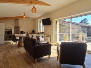 a living room with a table and chairs and a kitchen at L' Échappée Miel in Laitre-sous-Amance