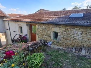 a stone house with a cat sitting in front of it at L' Échappée Miel in Laitre-sous-Amance