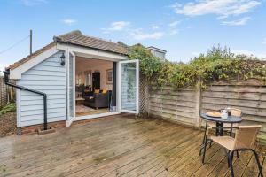 een patio met een tafel en stoelen op een houten terras bij 1 Bed in Hindhead oc-w34256 in Hindhead