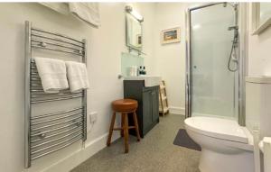 a bathroom with a toilet and a shower and a stool at Clune House B&B in Newtonmore +24 photos