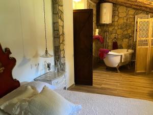 a bedroom with a bathroom with a tub and a sink at Masiadenjust in Rojals