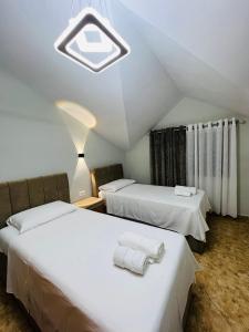 a bedroom with two beds with towels on them at Potka Apartments Tirane in Yzberishti
