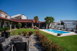 a backyard with a swimming pool and a resort at Villa dos Corcéis in Esposende