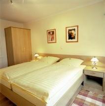 Hotel Veltrup في Laer: غرفة نوم بسرير وطاولة مع مصباح