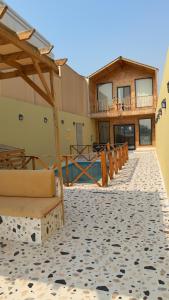a building with a patio with chairs and a deck at درة العروس اكواخ الدره in Durat Alarous