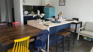 a kitchen with blue cabinets and a wooden table and chairs at Chata z Kraja in Józefów