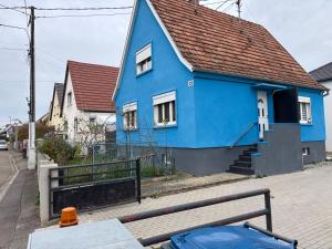 a blue house on the side of a street at Maison chaleureuse Calme et tranquillité assurés Parking privé in Geispolsheim