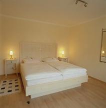 a bedroom with a white bed with two lights on it at Hotel Veltrup in Laer