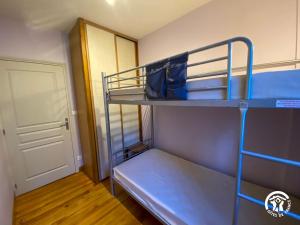 a small room with two bunk beds and a door at Gîte du Cassan in Sénergues