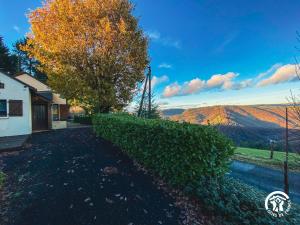 a house with a tree and a view of the mountains at Gîte du Cassan in Sénergues