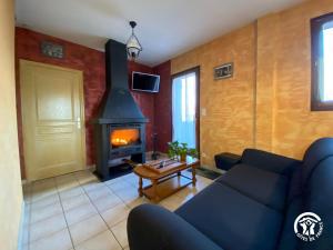 a living room with a couch and a fireplace at Gîte du Cassan in Sénergues
