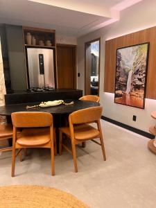 a dining room with a black table and chairs at Mucugê- Charm Village in Mucugê