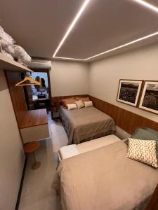 a bedroom with two beds and a desk and a room at Mucugê- Charm Village in Mucugê +18 photos