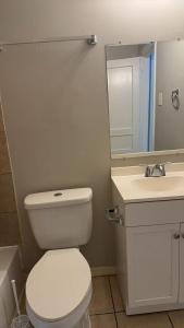 a bathroom with a white toilet and a sink at Only 25 dollars-Man's bed in a room in Texas City