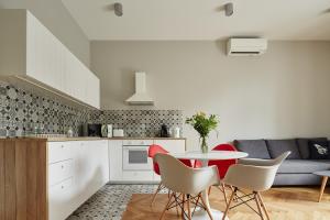 a kitchen and living room with a table and chairs at PlayRoom Aparthotel in Krakow +158 photos