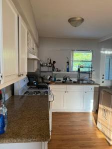 a kitchen with white cabinets and a stove top oven at Only 25 dollars-Man's bed in a room in Texas City