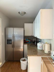 a kitchen with a stainless steel refrigerator and white cabinets at Only 25 dollars-Man's bed in a room in Texas City