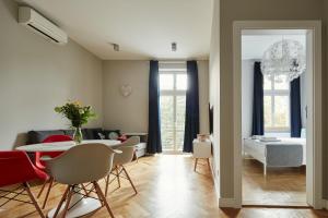 a living room with a table and chairs and a bedroom at PlayRoom Aparthotel in Krakow