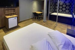 a room with a bed and a table and a desk at Motel Desert-Inn in Valinhos