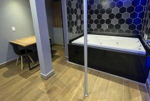 a bath tub in a room with a table at Motel Desert-Inn in Valinhos