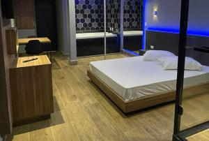 a bedroom with a bed in a room with blue lights at Motel Desert-Inn in Valinhos