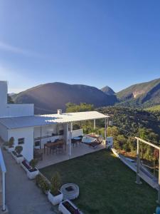 a white house with a patio with a table at Encantos do vale Teresópolis in Teresópolis