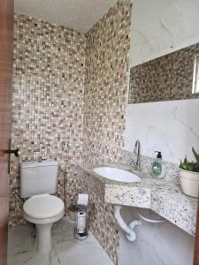 a bathroom with a toilet and a sink at Encantos do vale Teresópolis in Teresópolis