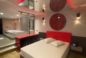 a bedroom with a red bed and a bath tub at Motel Desert-Inn in Valinhos