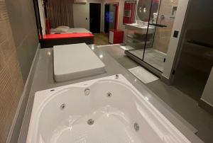 a large bath tub in a bathroom with a bedroom at Motel Desert-Inn in Valinhos +14 photos