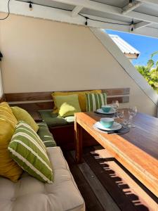 een patio met een tafel en een bank bij Studio Coconut in Baie Nettle