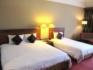 Postel nebo postele na pokoji v ubytování Hotel Grand Continental Kuching