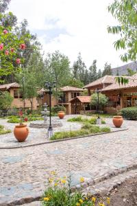 a courtyard with flower pots in front of a building at Tariq Sacred Valley in Urubamba