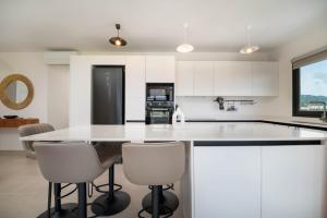 a kitchen with white cabinets and a large white island at Laena Lodge in Papeete