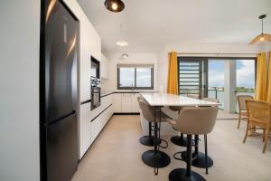a kitchen with a black refrigerator and a table at Laena Lodge in Papeete
