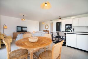 a kitchen and living room with a wooden table and chairs at Laena Lodge in Papeete