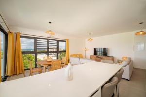 a kitchen and living room with a table and chairs at Laena Lodge in Papeete