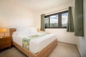 a bedroom with a large bed and a window at Laena Lodge in Papeete +8 photos