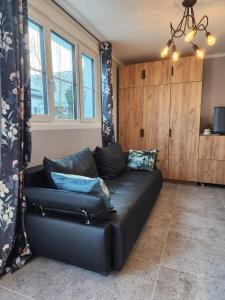 a black leather couch in a living room with windows at Pamir in Ferdinandshof