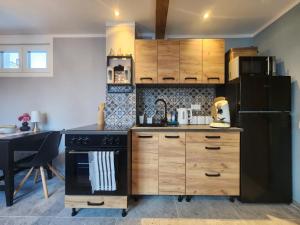 a kitchen with wooden cabinets and a black refrigerator at Pamir in Ferdinandshof