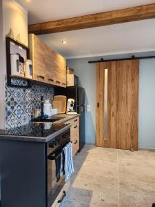 a kitchen with wooden cabinets and a black stove top oven at Pamir in Ferdinandshof